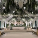 Elegant wedding stage with chandeliers and floral decor.
